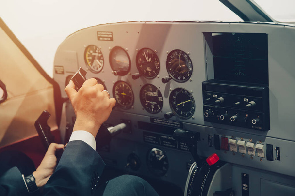 Pilot hand or private flight captain control airplane with many aircraft gauge in cockpit dashboard. - Фото, зображення