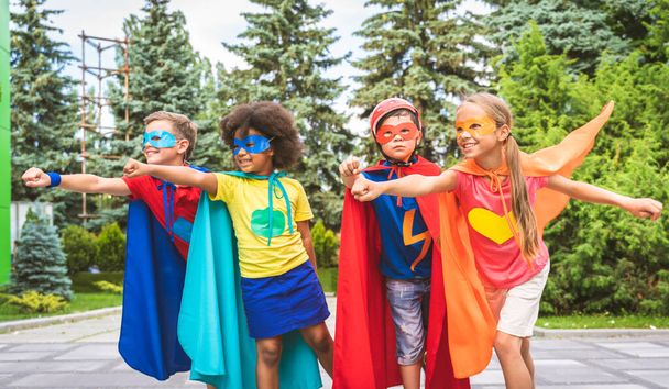 Multiracial group of young schooler wearing superhero costumes and having fun outdoors - Φωτογραφία, εικόνα