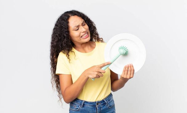 pretty hispanic woman holding an empty clean dish - Foto, Bild