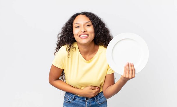 pretty hispanic woman holding an empty clean dish - Фото, зображення