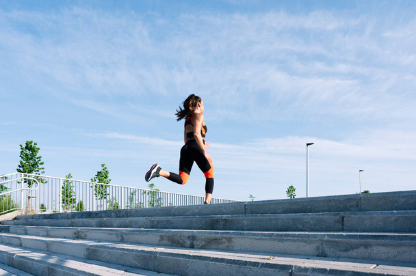 Jeune femme sautant les escaliers d'entraînement dans la ville - Photo, image