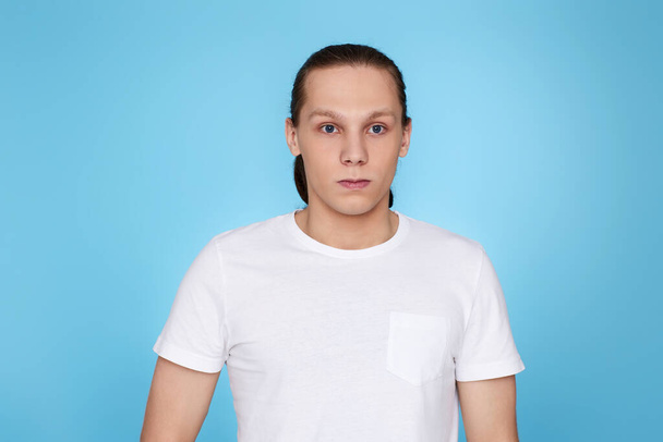 young man frowning isolated on blue background. - Fotografie, Obrázek