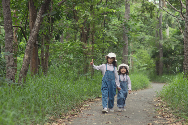 Les enfants se dirigent vers le camping familial dans la forêt Promenade le long de la route touristique. Route de camping. Voyage en famille concept de vacances. - Photo, image