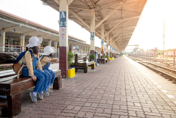 鉄道駅の二人の女の子列車を待っている  - 写真・画像