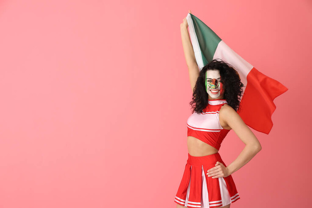 Hermosa animadora con bandera mexicana sobre fondo rosa - Foto, Imagen
