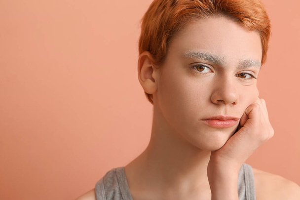 Teenage boy with dyed eyebrows on color background - Фото, изображение