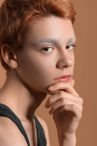 Teenage boy with dyed eyebrows on color background, closeup - Фото, зображення