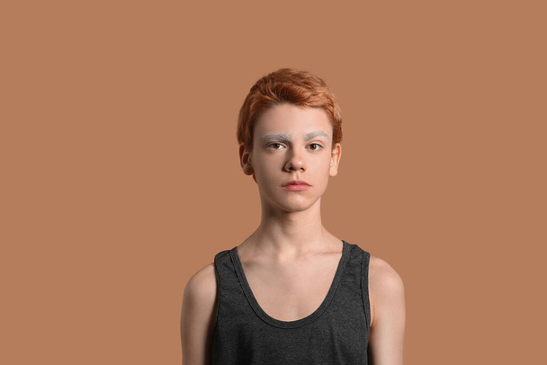 Мальчик-подросток с крашеными бровями на цветном фоне - Фото, изображение