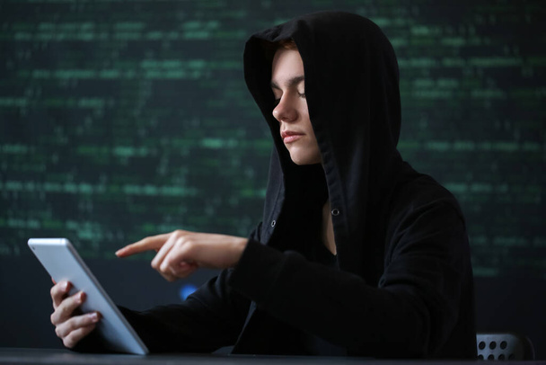 Hacker con tablet sobre fondo oscuro - Foto, imagen