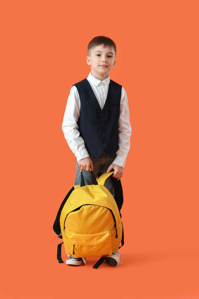 Little schoolboy with backpack on color background - 写真・画像
