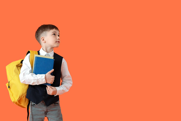 Piccolo scolaro con libri su sfondo a colori - Foto, immagini