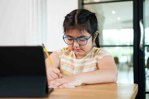 Söpö ja onnellinen pikkutyttö lapset käyttävät kannettavaa tietokonetta, opiskelevat online-verkko-oppimisjärjestelmän kautta. - Valokuva, kuva