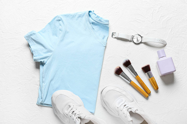 Composition with stylish t-shirt, shoes and accessories on light background - Foto, imagen