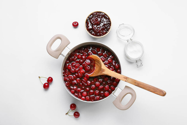 Composition with tasty cherry jam on white background - Foto, afbeelding