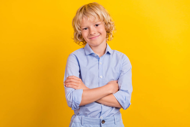 Photo of cool little boy crossed arms wear blue shirt isolated on yellow color background - Фото, зображення