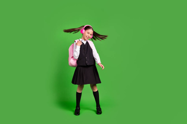 Full length body size view of attractive cheerful girl having fun listening hit isolated over bright green color background - 写真・画像