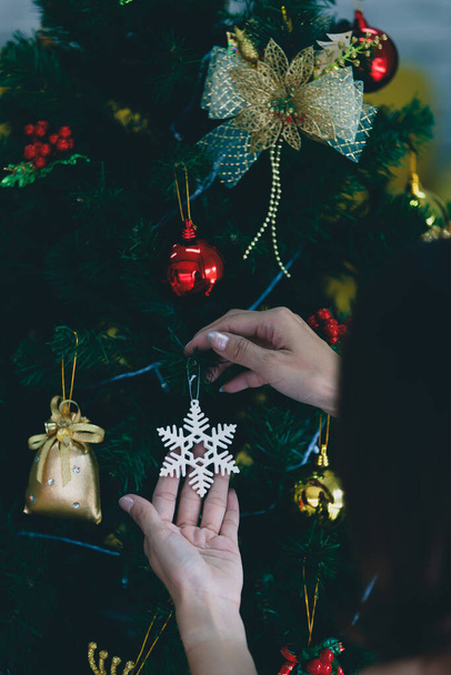Hands of woman hoding fake snow flake for decorate on christmas tree prepare for festival. - Foto, Imagen