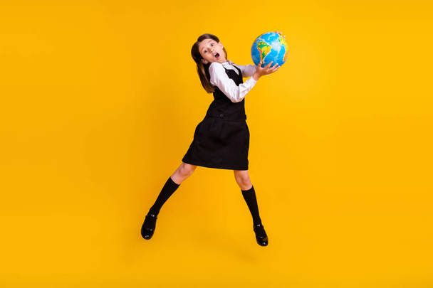Full length body size photo schoolgirl amazed jumping with globe on geography isolated vivid yellow color background - Fotoğraf, Görsel