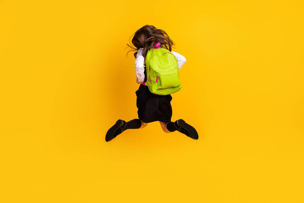 Full length body size back view photo schoolgirl jumping running to school isolated vibrant yellow color background - Zdjęcie, obraz