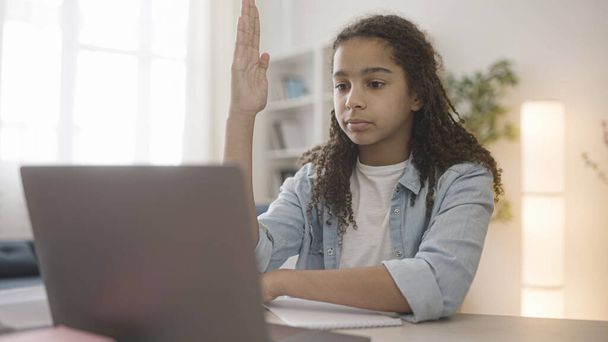 Black teen girl answering teacher while having online lesson, distance learning - Foto, Imagen