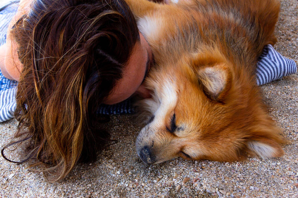 Femme allongée sur une serviette embrassant son chien avec amour. Concentration sélective. Espace de copie. - Photo, image