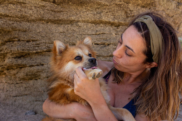 Blonde woman with headband in nature playing with her dog. Selective focus. Copy space. - Foto, imagen