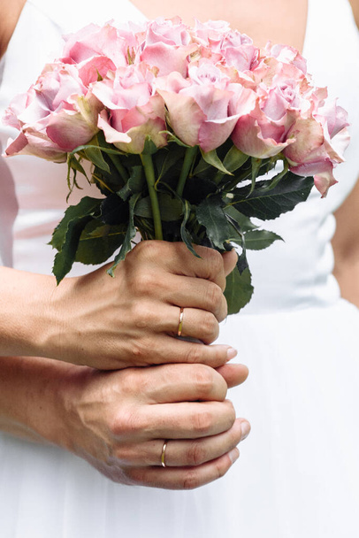handen van jonge mensen met trouwringen. trouwdag details. calla bloemen. echtgenoten - Foto, afbeelding