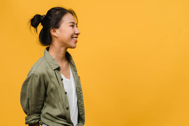Портрет молодой азиатки с позитивным выражением лица, широко улыбающейся, одетой в повседневную одежду на желтом фоне. Счастливая очаровательная счастливая женщина радуется успеху. Концепция выражения лица. - Фото, изображение