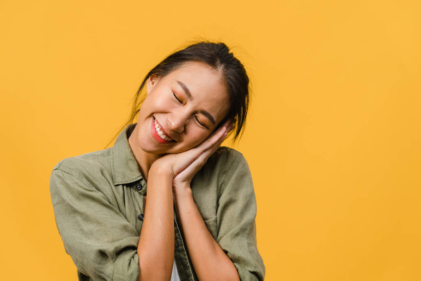 Portrait of young Asia lady with positive expression, smile broadly, dressed in casual clothing over yellow background. Happy adorable glad woman rejoices success. Facial expression concept. - Foto, afbeelding