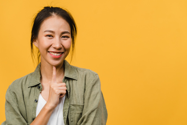 Young Asia lady with positive expression, smile broadly, dressed in casual clothing and looking at camera over yellow background. Happy adorable glad woman rejoices success. Facial expression concept. - Φωτογραφία, εικόνα