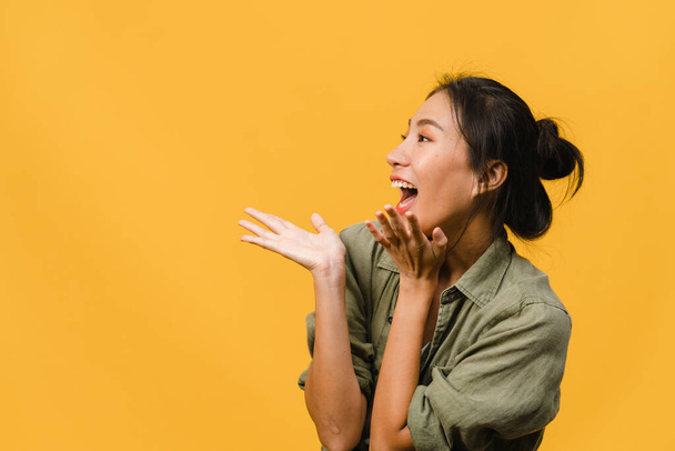 Young Asia lady feel happiness with positive expression, joyful surprise funky, dressed in casual cloth isolated on yellow background. Happy adorable glad woman rejoices success. Facial expression. - Photo, Image