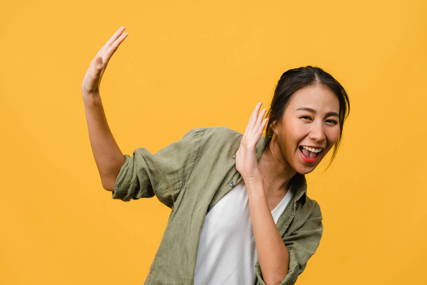 Young Asia lady feel happiness with positive expression, joyful surprise funky, dressed in casual cloth and looking at camera isolated on yellow background. Happy adorable glad woman rejoices success. - Foto, imagen