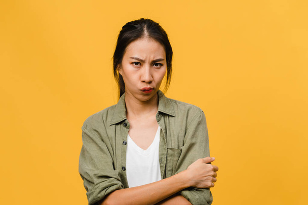 Olumsuz ifadeli genç Asyalı kadın, çığlık çığlığa ağlayan, günlük kıyafetlerle öfkeli ve sarı arkaplanda boş fotokopi alanı ile izole edilmiş kameraya bakın. Yüz ifadesi kavramı - Fotoğraf, Görsel