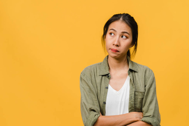 Portrait of young Asia lady with negative expression, excited screaming, crying emotional angry in casual clothing isolated on yellow background with blank copy space. Facial expression concept. - Photo, Image