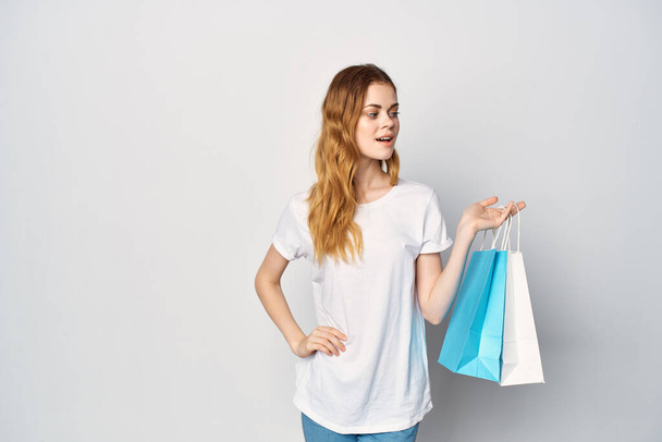mujer con paquetes en las manos compras entretenimiento divertido fondo de luz - Foto, Imagen