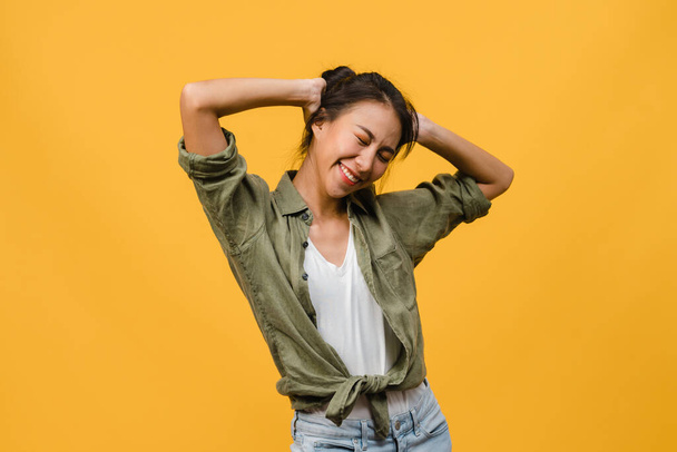 Portrait of young Asia lady with positive expression, smile broadly, dressed in casual clothing over yellow background. Happy adorable glad woman rejoices success. Facial expression concept. - Foto, afbeelding