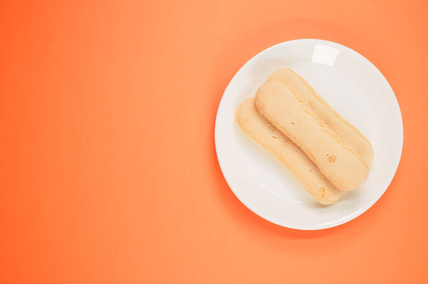 A top view of ladyfinger cookies on a plate isolated on an background - 写真・画像