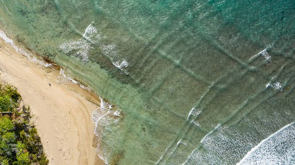A sandy beach of an azure ocean viewed from above - Photo, image