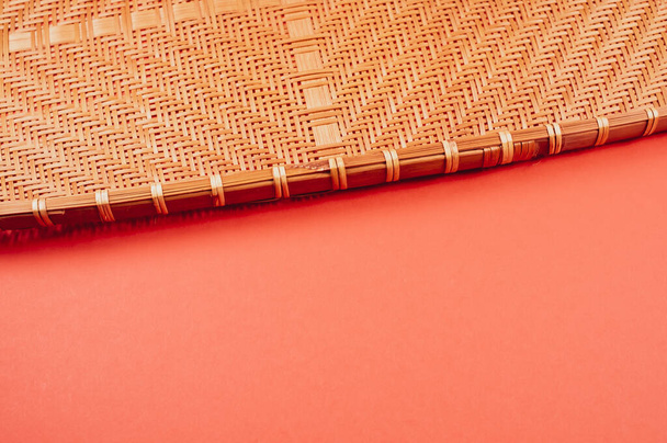 Una vista superior de bandeja de mimbre de bambú aislada sobre fondo rojo - Foto, Imagen