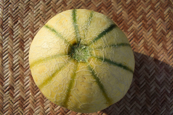 Indian muskmelon fruit or Cantaloupe. Healthy organic fruit and vegetable farm fresh on nature outdoors background. Cantaloupe or kharbooja yellow with green verticle stripes. Asian fruits - Photo, Image