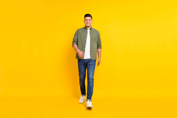 Full length body size photo guy walking forward isolated vibrant yellow color background - Foto, Imagen