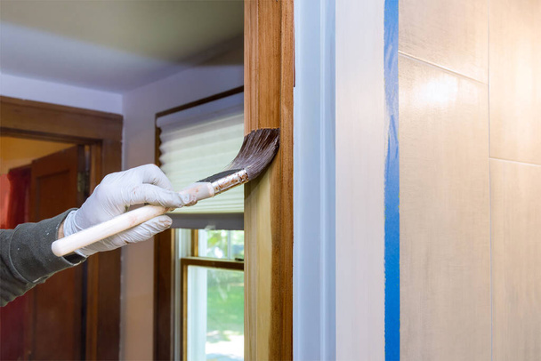 Hand des Reparateurs Malerei mit Handschuhen in den Pinsel auftragen Lack Farbe Holz Türen Formen trimmen mit Pinsel - Foto, Bild