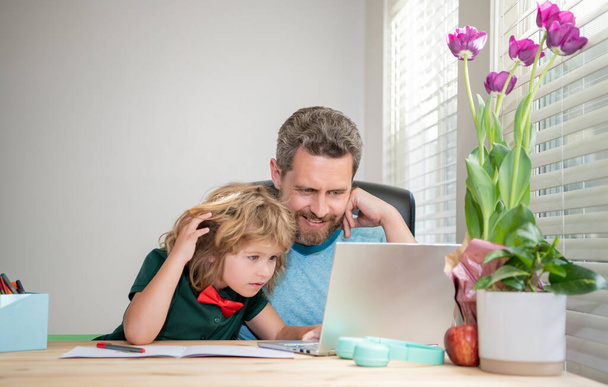 Ojciec i syn używają komputera w domu. Szczęśliwego rodzinnego bloga. chłopiec zrobić pracę domową z prywatnym nauczycielem - Zdjęcie, obraz