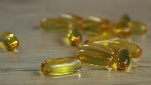 omega 3 capsule di olio di pesce si trovano su un tavolo di legno. - Filmati, video