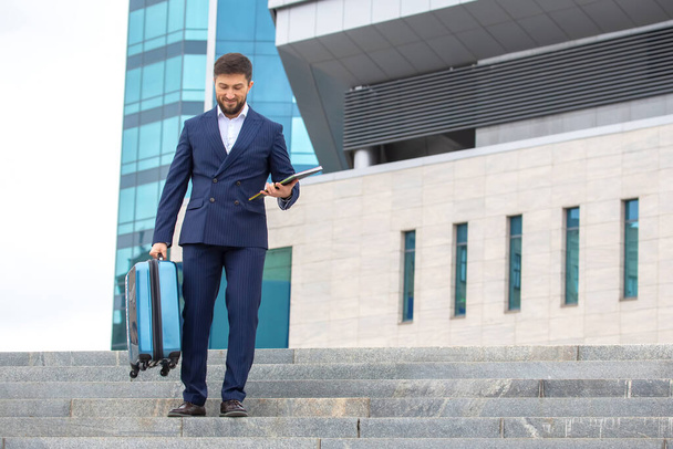 успешный бизнесмен спускается по ступеням на фоне офисного бизнес-центра - Фото, изображение