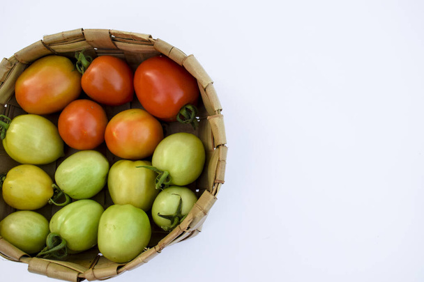 Drei verschiedene Sorten Tomaten. grüne, gelbe, rote Tomate in einem Korb auf weißem Hintergrund - Foto, Bild