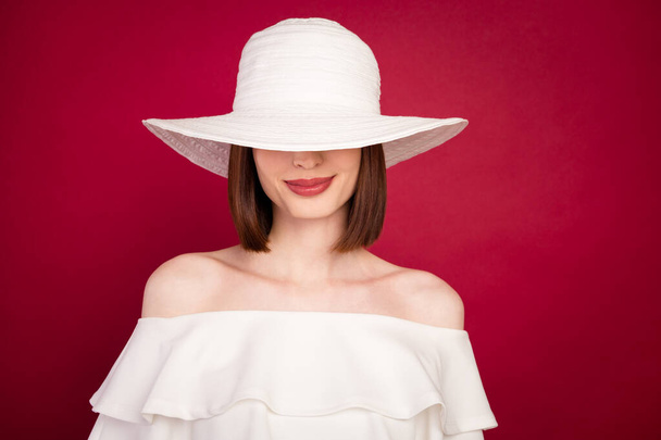 Photo of young attractive woman happy positive smile incognito cover eyes hat isolated over red color background - Фото, изображение
