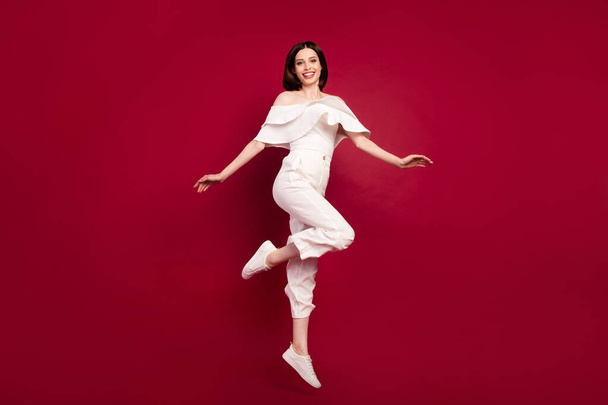 Full length body size photo pretty brunette jumping up smiling isolated red color background - 写真・画像