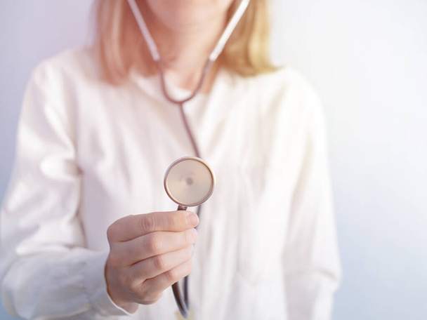 portret van vrouwelijke arts luisteren naar hart en ademhaling, zetten stethoscoop, foto - Foto, afbeelding