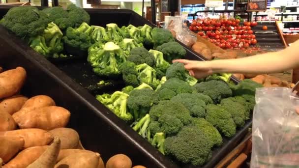 Donna che seleziona broccoli freschi nel reparto prodotti alimentari
. - Filmati, video